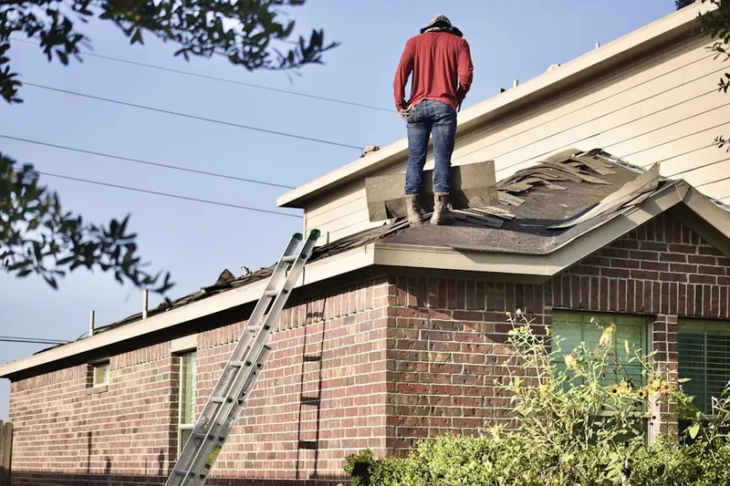 Professional roofer working on a residential roof in Hampton Bays